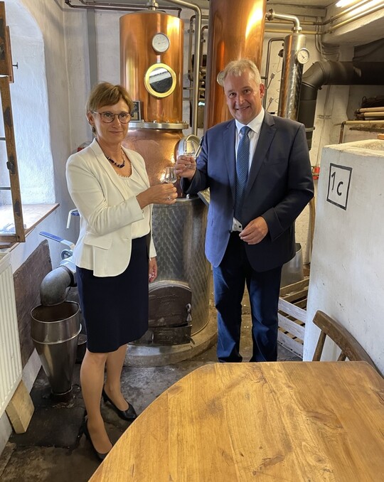 Die Staatssekretrin Sabine Kurtz und der 1. Vorsitzende Karl Mller stoen mit einem Hohenloher Birnenbrand auf die erfolgreiche Eintragung dieser Spezialitt in das zentrale europische Register fr geografische Herkunftsangaben eAmbrosia an.