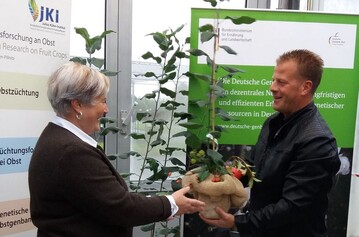 Die Leiterin des Julius-Khn-Instituts, Prof. Dr. Viola Hanke, bergibt Kreisfachberater Alexander Ego (LRA Biberach) den Urbaum-Klon des Jakob Fischer-Apfels