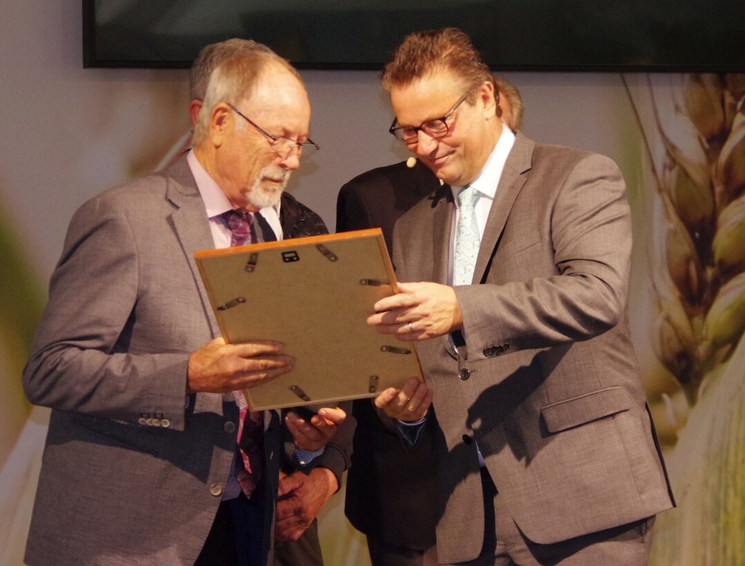 Landwirtschaftsminister Hauk (r.) überreicht Dr. Hartmann die Urkunde