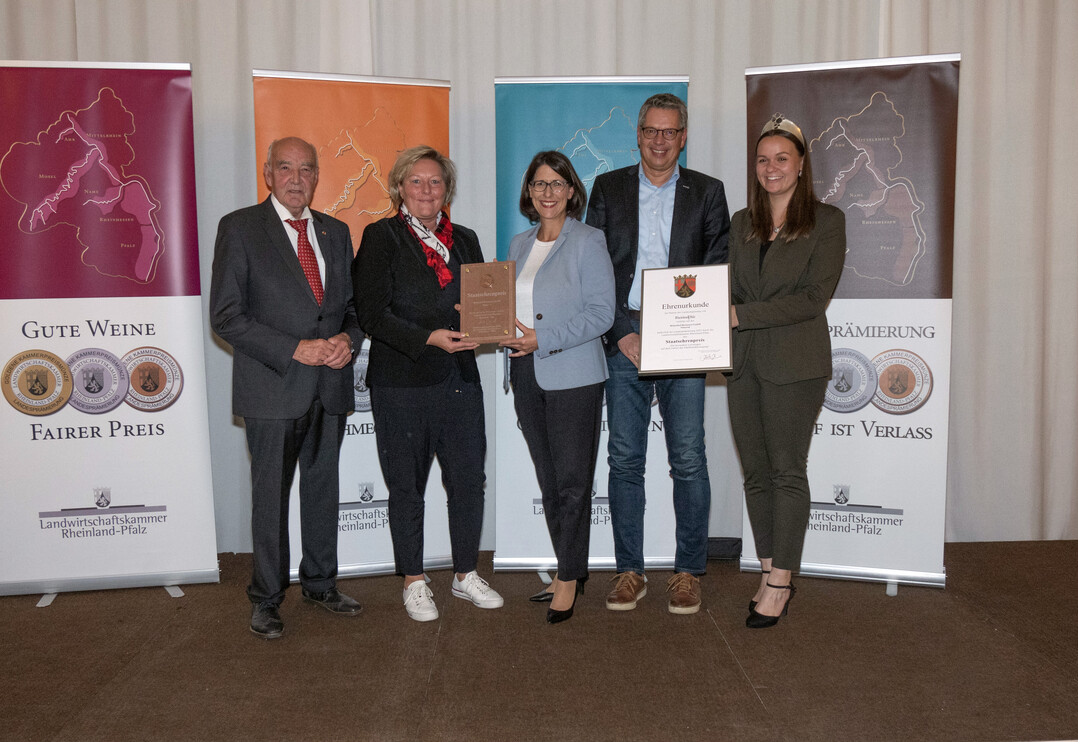Die Birkenhof-Brennerei GmbH Nistertal erhält den Staatsehrenpreis von Kammerpräsident Ökonomierat Norbert Schindler, Wirtschaftsministerin Daniela Schmitt und der Moselweinkönigin Sarah Röhl.